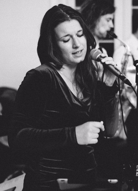 Sängerin schwarz-weißes Mikrofon schwarzes Kleid für Party Hochzeit Jazz live Saxophonist dressup Jazz für Hochzeit Jazz für Party Band für Hochzeit Band für Party