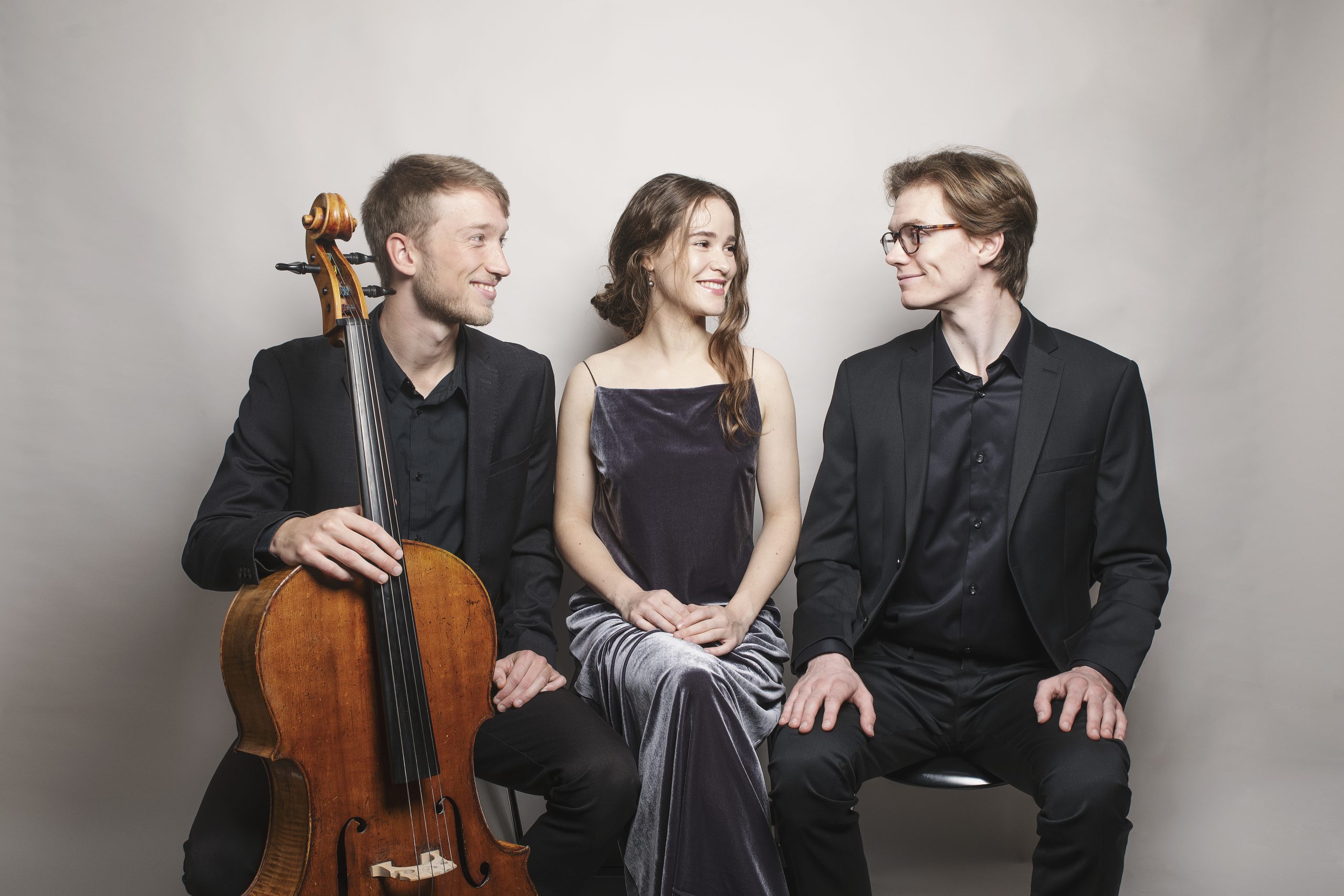 Klassisk trio med cello og sangere smiler til hinanden i studieopsætning og er klar til at levere koncertmusik til bryllup og events.