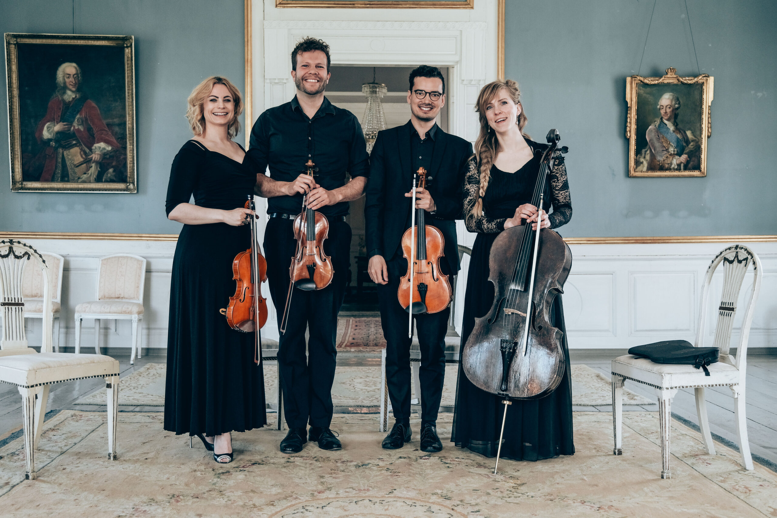 Fire klassiske musikere poserer med deres strygeinstrumenter i lys sal til præsentation af bryllupsmusik.