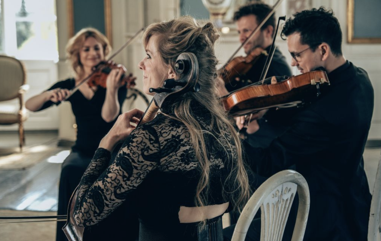 Violinist spiller tæt på publikum i stemningsfulde omgivelser, hvor fokus ligger på håndværk, nærvær og den musikalske oplevelse